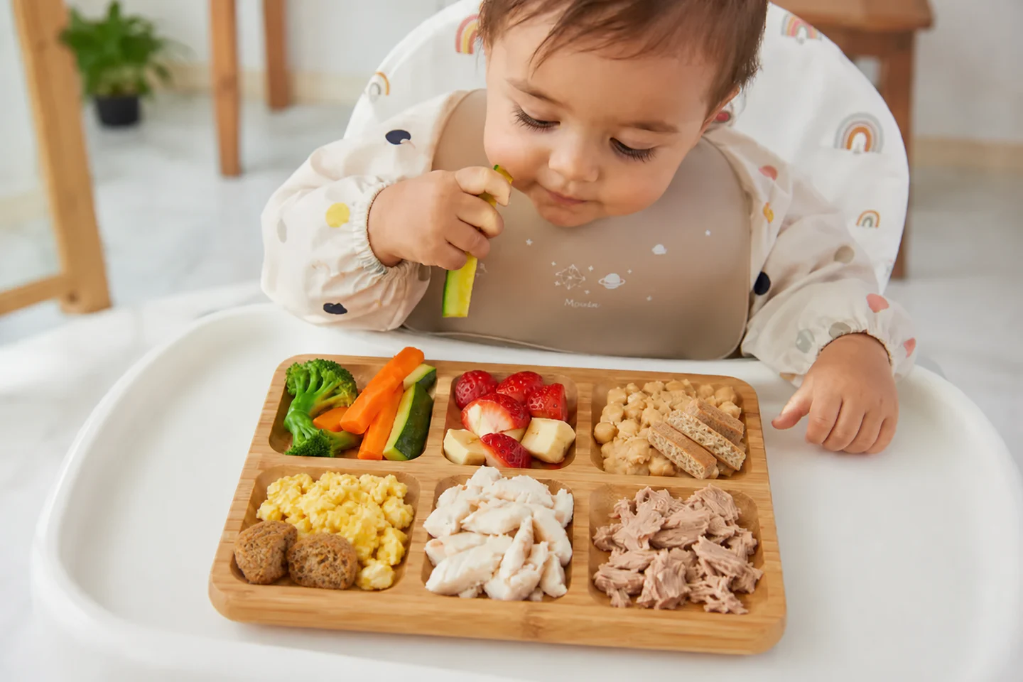 Peque explorando alimentos y trocitos de Tuti Pancakes y MINIS desde su trona